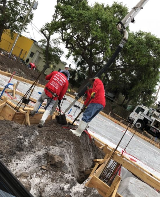 placing concrete two construction workers with shovels